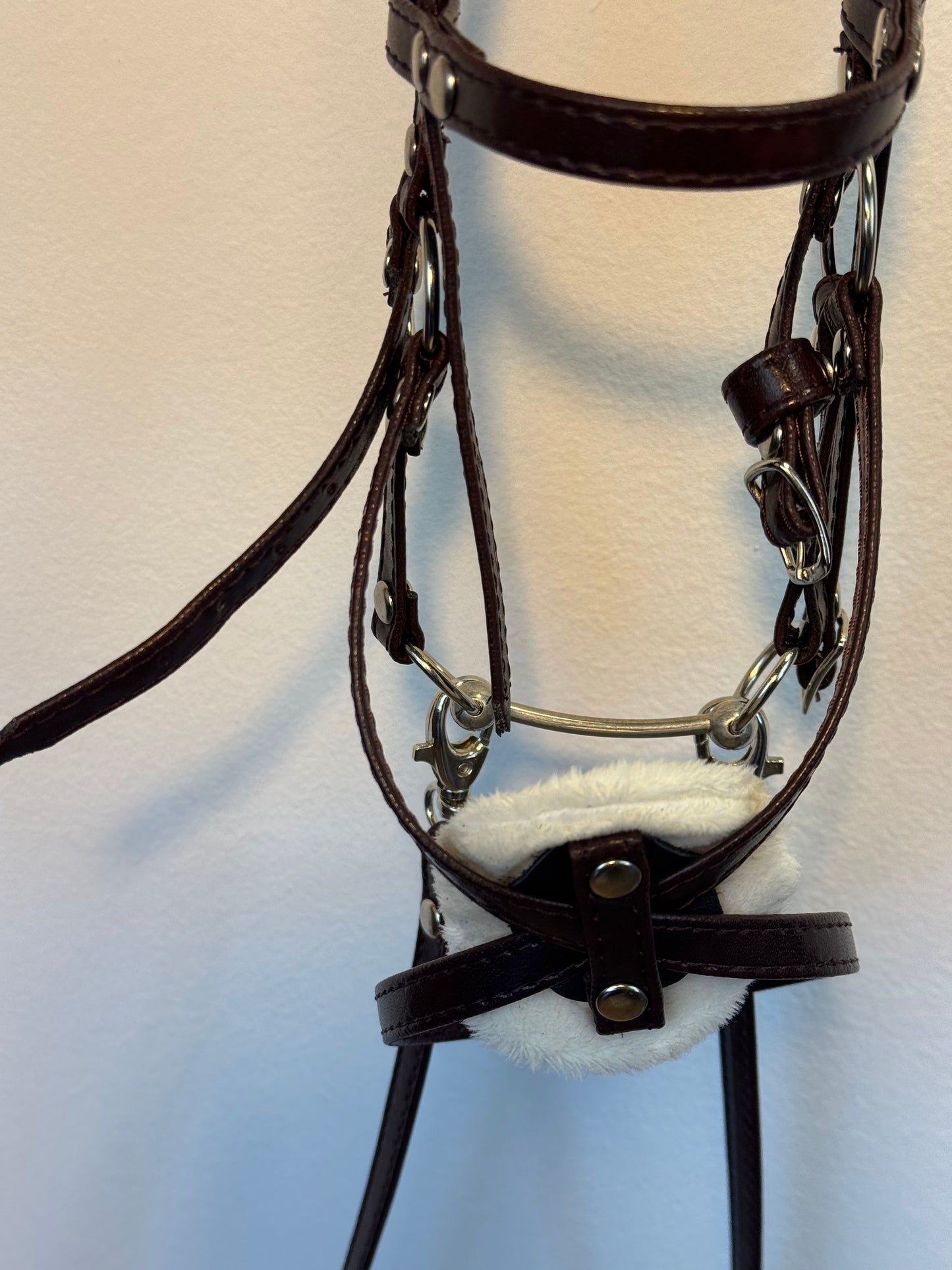 Hackamore-Zaumzeug aus Öko-Leder mit Blumenmuster und diamantförmigem Stirnband. Braun. Passend für Steckenpferde in den Größen A5, A4 und A3.